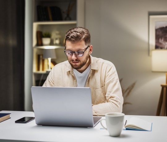 mand sidder foran sin pc og kigger bilforsikringer igennem