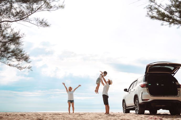 Familie med bil på stranden