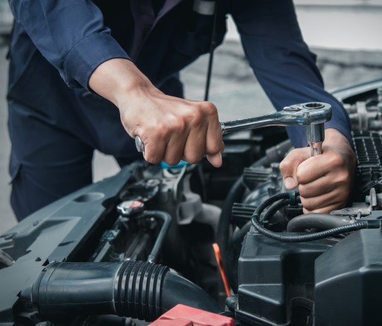 mekaniker fikser motor i bil med det rette udstyr