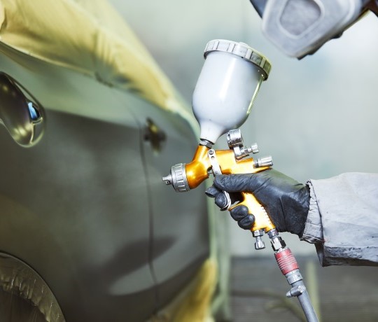 mekaniker laver autolakering på sort bil