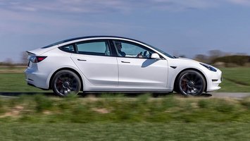 Tesla Model 3 ses fra siden.