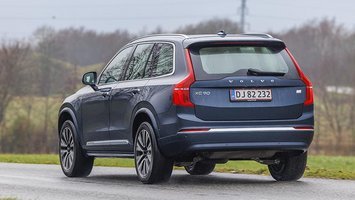 En Volvo XC90 ses bagfra, mens den kører på landevej i gråvejr