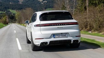 Hvid Porsche Cayenne set bagfra kører på lige landevej