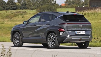 Hyundai Kona set bagfra, mens den kører på en landevej.