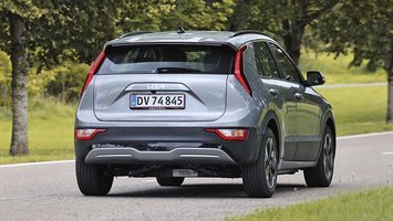 Elbilen Kia Niro set bagfra, mens den kører ned ad en allé.