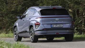 Elbilen Hyundai Kona set bagfra, mens den kører på en skovvej.