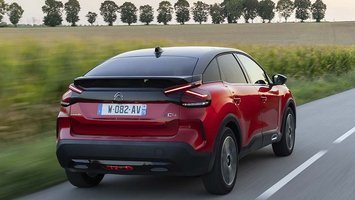 Elbilen Citroën Ë-C4 set bagfra, mens den kører langs en mark.