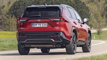 En rød Toyota RAV4 set bagfra, mens den kører på en bugtet landevej
