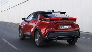 En rød Toyota C-HR set bagfra, mens den kører på en motorvej
