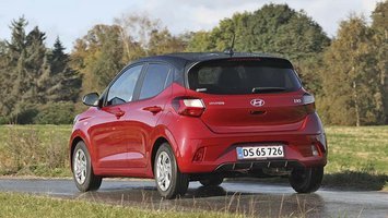 En rød Hyundai I10 set bagfra på en landevej