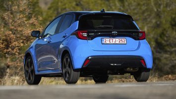 Blå Toyota Yaris set bagfra med træer i baggrunden