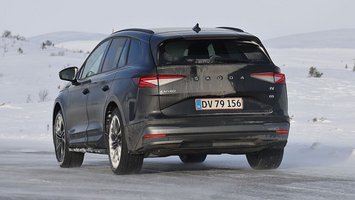 Sort Skoda Enyaq set bagfra, mens den kører på snedækket landevej
