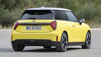 En gul Mini Cooper set bagfra, mens den holder stille