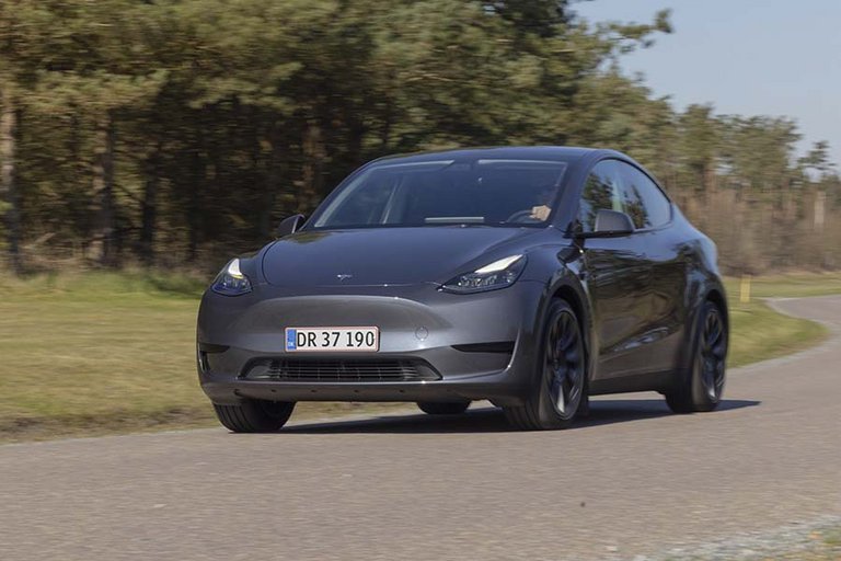 Tesla Model Y set forfra, mens den kører på en landevej