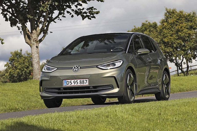 Elbilen VW ID.3 set forfra, mens den kører på landevej med træer i baggrunden.
