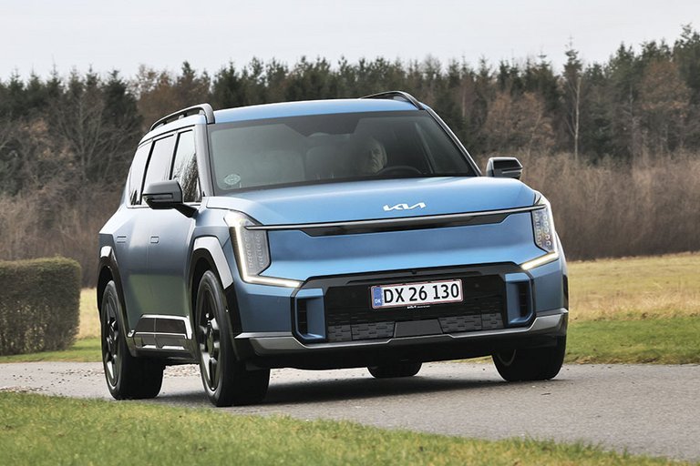 En blå Kia EV9 elbil kører på en landevej