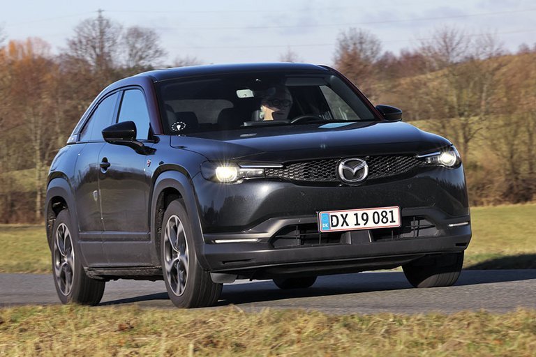 En sort Mazda MX-30 R-EV kører på en landevej