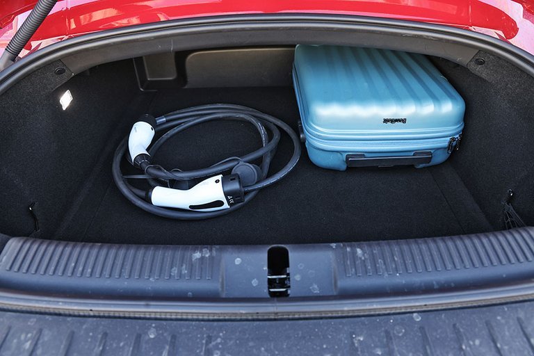Bagagerum med kabel og blå kuffert i en MG Cyberster