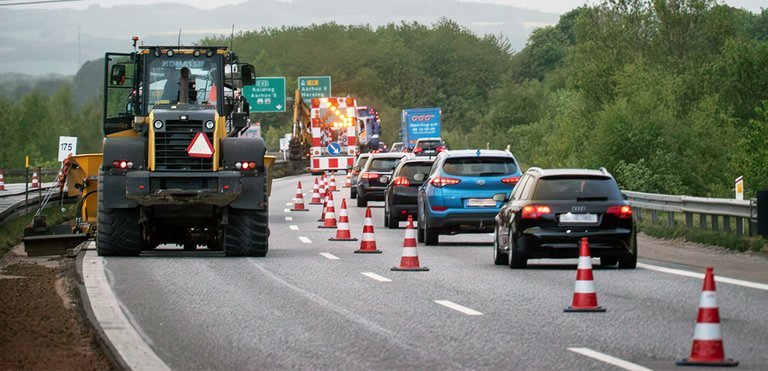 Motorvej E45 mellem Vejle og Aarhus kan ofte være en plage med tæt og langsom trafik, og når der sker ulykker eller blot bil havarerer, kan køerne blive særdeles lange. På de mest trafikerede strækninger kører der over 90.000 biler i døgnet. Men nu er hjælpen på vej. Hele Østjyske Motorvej udbygges til seks spor. Som det normalt er tilfældet med de store vejudvidelser, skal det være værre, før det i sidste ende bliver godt. Tre et halvt års vejarbejde på Østjyske Motorvej går så småt i gang nu, inden den helt store armada af gravemaskiner og bulldozere sættes ind i foråret 2024. Der skal arbejdes på 38 km mellem Vejle nord og Skanderborg syd samt 18 km rundt om Aarhus. I alt 56 km bliver udvidet til en forventet pris på 5,6 mia. kr. Mellem Vejle og Skanderborg er punktvise vejarbejder af mest kortere varighed gået i gang. Bl.a. bliver de to første af otte broer over motorvejen revet ned fra oktober. Det og andre mindre arbejder vil typisk betyde, at fartgrænsen sænkes til 80 km i timen på kortere strækninger. Enkelte gange, typisk om natten, kan grænsen blive sænket til 50 km/t. Den egentlige vejudvidelse, som bliver mærkbar for trafikanterne, går i gang i foråret 2024. De 38 km er delt op i syv etaper á ca. seks-syv km, og der begyndes både fra syd og nord, inden turen kommer til den sidste delstrækning omkring Horsens. Når ud arbejdet står på i fuldt omfang, vil det betyde fire smalle vognbaner og en fartgrænse på 80 km i timen. Det samme gælder for den nordlige del af E45, 16 km rundt om Aarhus og to km af Djurslandsmotorvejen. De første ca. seks km med 80 km/t. og smallere vognbaner er allerede en realitet, og fra nu af vokser vejarbejdet i udstrækning, først i den sydlige ende. Fra foråret 2024 vil hele den ydre omfartsvej om Aarhus være et stort vejarbejde. Arbejdet på Djurslandsmotorvejen begynder dog lidt senere. Vejdirektoratet har endnu ikke regnet på, hvor store forsinkelser vejarbejdet gennem mere end tre år vil betyde. Projektchef for den nordlige del, Robin Højen Madsen, siger, at trafikanternes tål