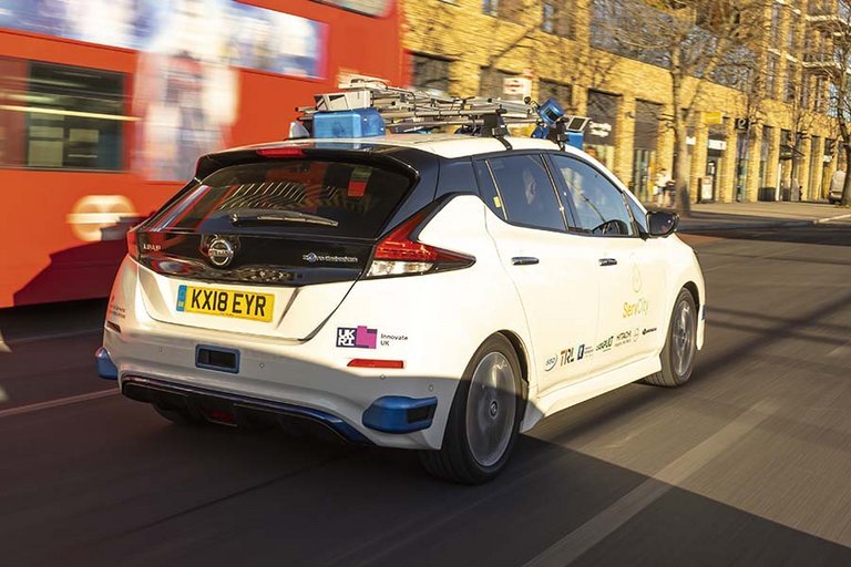 Selvkørende Nissan Leaf set bagfra, mens den kører igennem Londons trafik