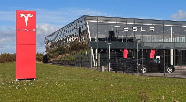 Tesla-forhandler med grøn græsplæne.