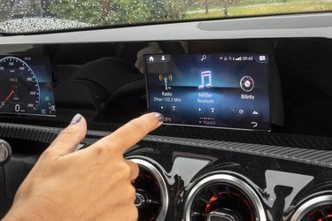 Skærmen kan betjenes ved hjælp af fingertryk, fra rattets knapper eller fra den store touchpad mellem forsæderne.