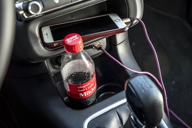 Kopholderne er placeret, så flasker står skævt i holderen. Dog er mobilhylden smart til hverdag, store mobiler kan dog ikke være der med ladestik. 