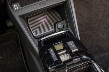 Mellem forsæderne er en meget lille gearvælger placeret sammen med knappen til styring af Drive Modes. Der er plads til en telefon med trådløs opladning lige under knapperne til varme- og ventilationsanlægget.