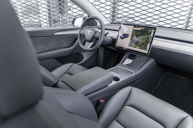 Den store midterkonsol rummer kopholdere og et stort opbevaringsrum. Der er opladning af mobilerne under skærmen.