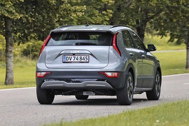 Kia Niro EV er en ret stor SUV-agtig bil med et stort bagagerum, der er dækket af en stor, tophængslet bagklap. Lygterne er placeret højt oppe ud for bagruden.