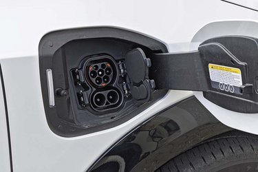Ladelugen er placeret ved højre forhjul, og den indbyggede lader giver mulighed for at AC-lade med op til 22 kW og DC-lade på farten med op til 130 kW. To dæksler vipper fint ud, blot man trykker på en knap på dækslet.
