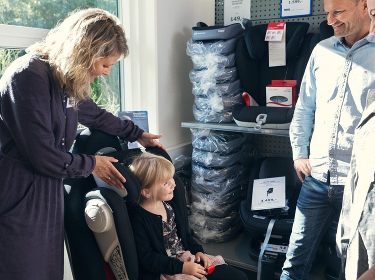 Pige prøver en autostol i en butik, som sælger autostole.