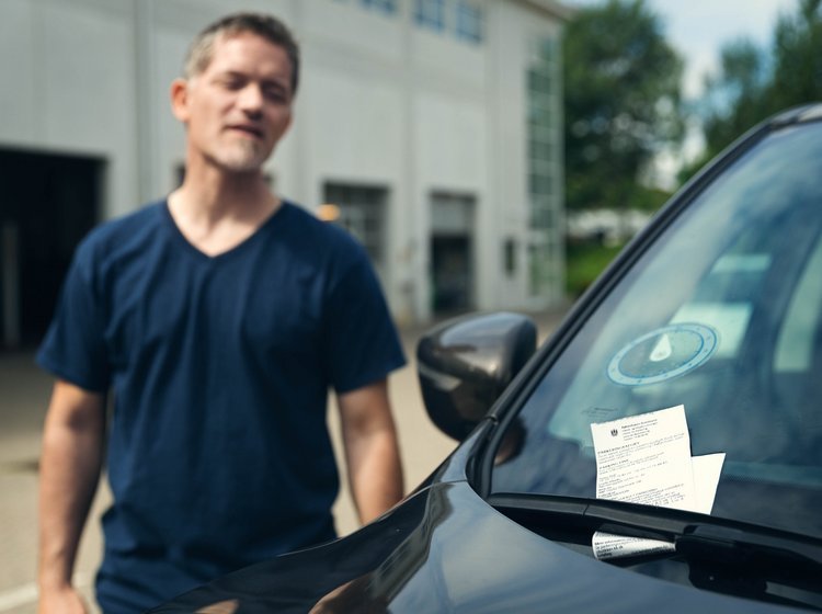 Mand opdager p-afgift på sin forrude. 