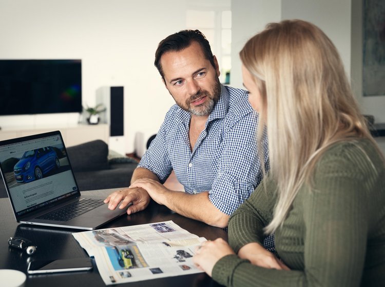 To personer sidder ved en computer og kigger på hinanden.