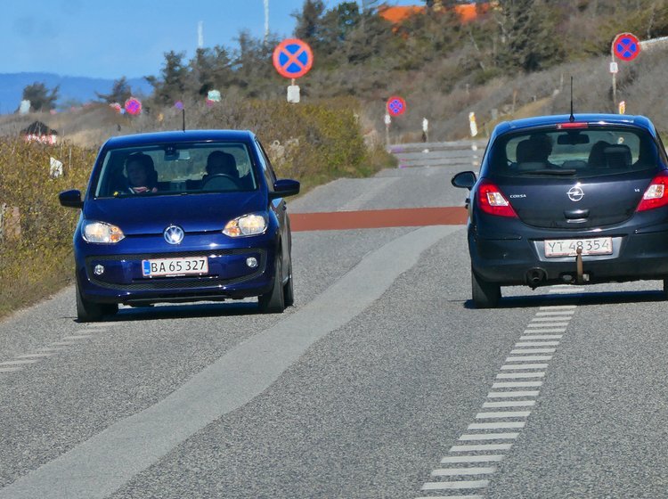 På en 2 minus en-vej skal man som udgangspunkt køre mellem striberne, men trække ud over dem, når der er modkørende..