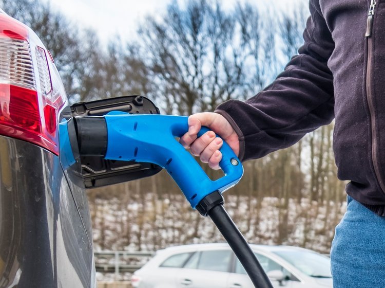 Mand ved dc-lader bil i koldt vejr