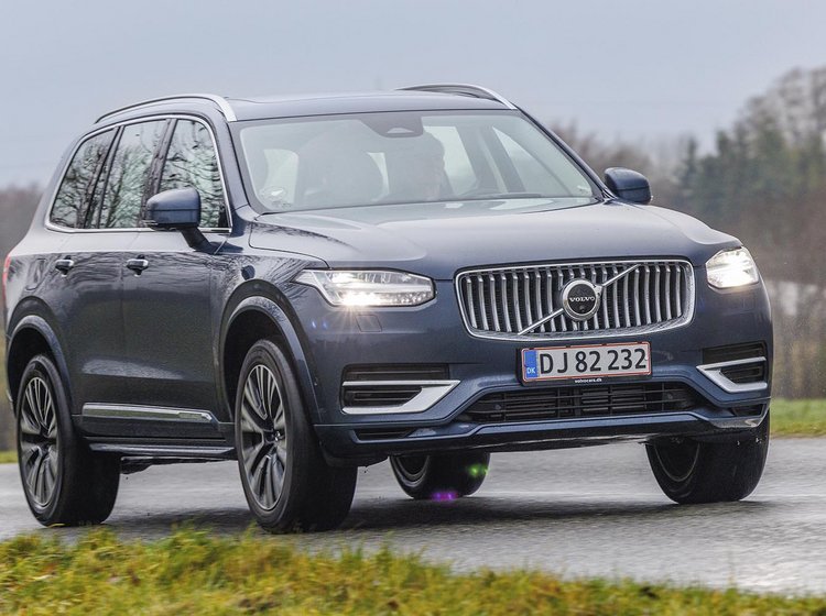 E mørke Volvo XC90 kører på landevej på en gråvejrsdag