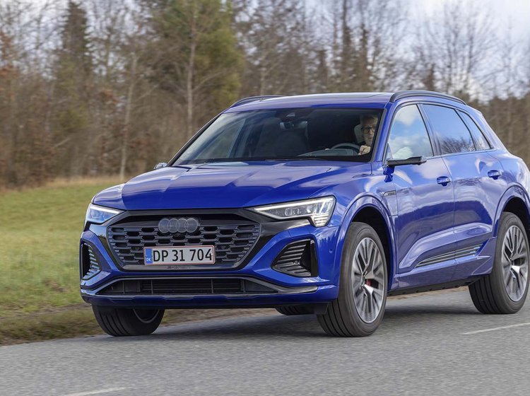 Elbilen Audi Q8 kører på landevej med græs i baggrunden