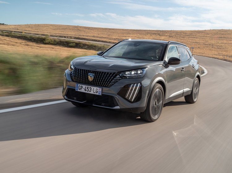 En Peugeot E-2008 kører i et sving på en landevej i høj fart