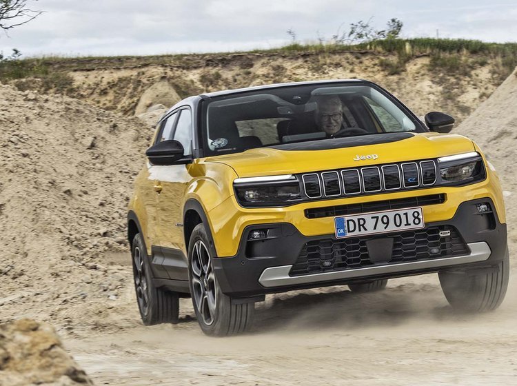 Gul Jeep Avenger kører på en grusvej