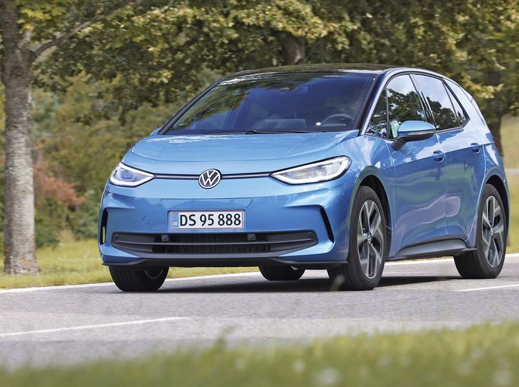 Elbilen VW ID.3 kører på en landevej med træer i baggrunden.