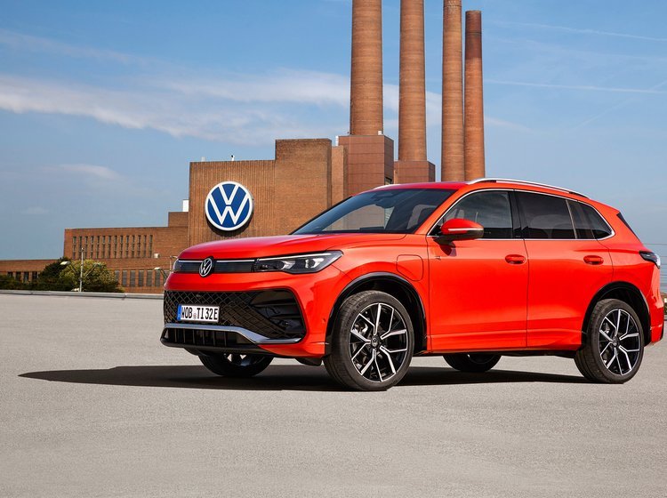 Rød VW Tiguan med fabriksskorstene i bagggrunden.