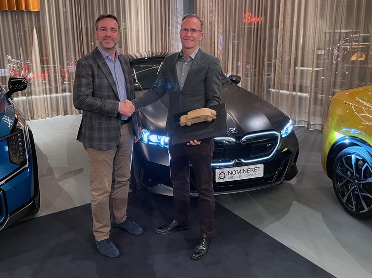 BMW i5 med to personer i forgrunden.