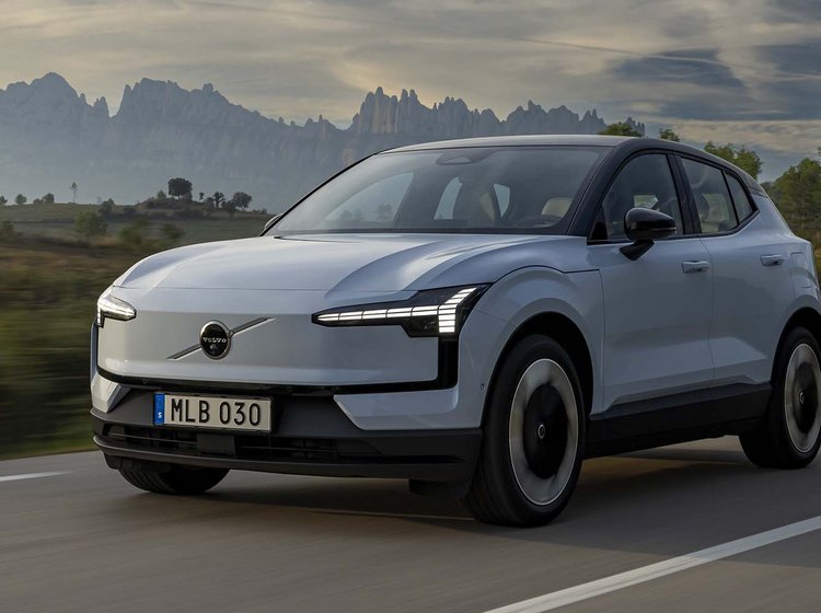 Elbilen Volvo EX30 kører på vej med bjerge i baggrunden.