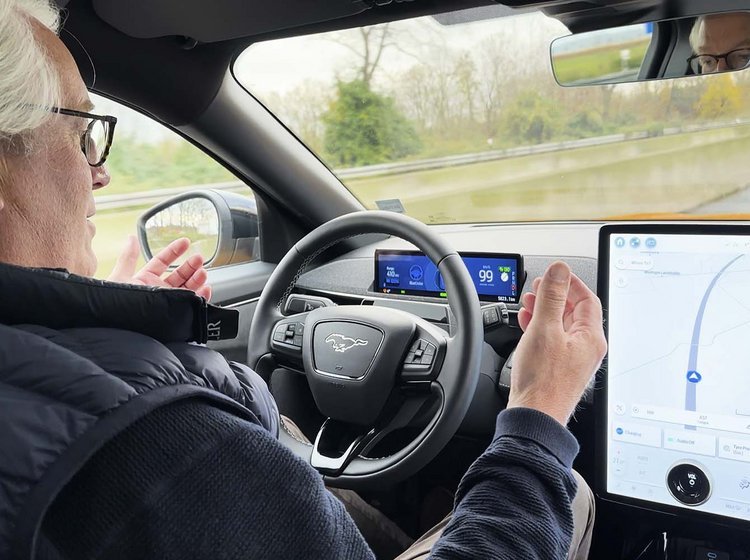 Fører sidder bag rattet uden hænder på rattet, mens bilen kører på motorvej.