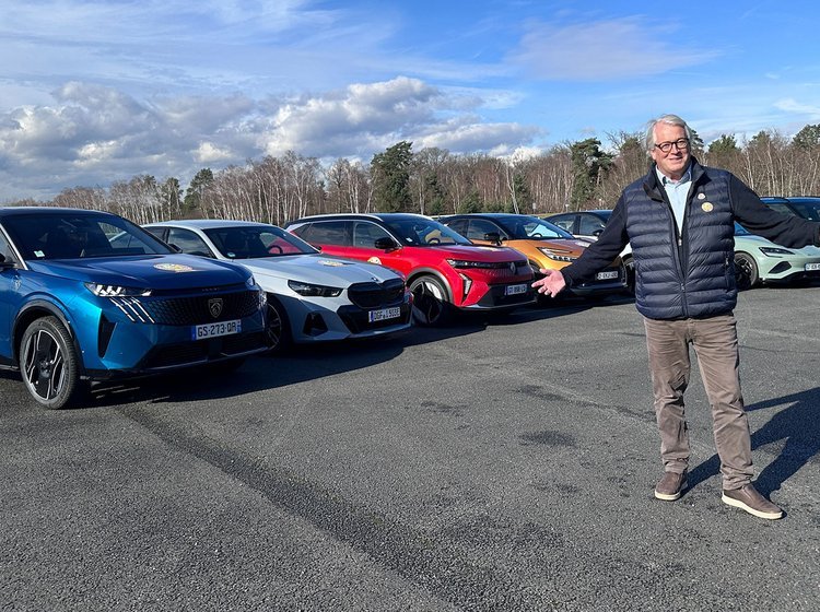 Person står foran 7 biler, der konkurrerer om at blive Car of the Year 2024