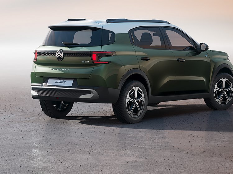 Citroën C3 i grønlig farve med hvidt tag set skrået bagfra.