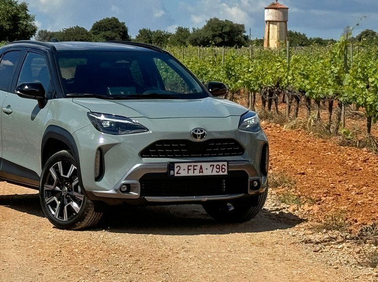 Toyota Yaris Cross holder på en grusvej med vinmarker rundt om