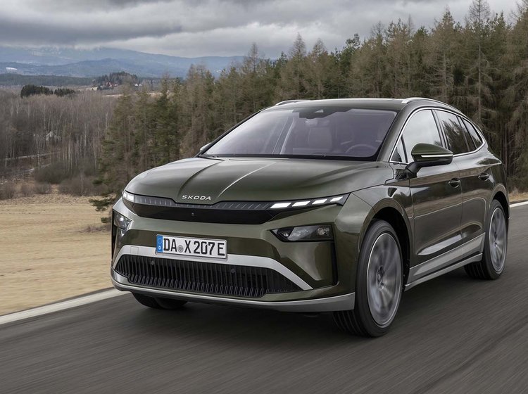 Skoda Enyaq set forfra, mens den kører på vej med træer i baggrunden