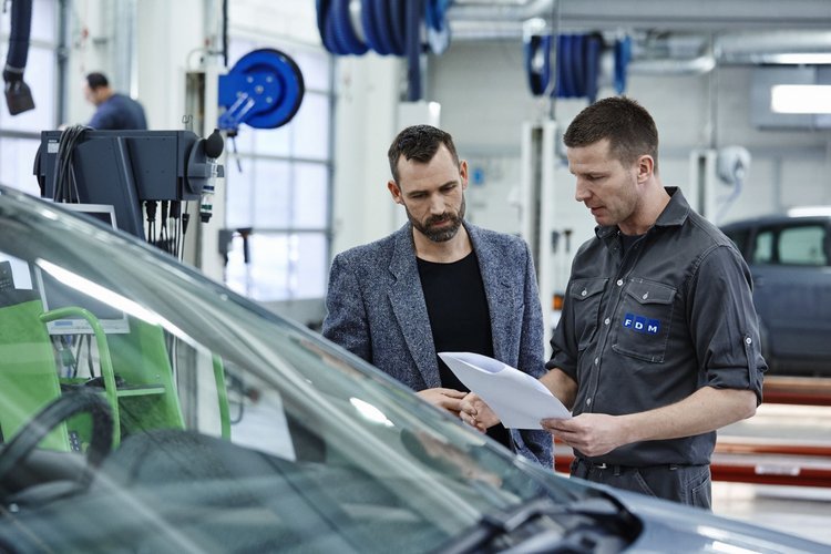 to mænd gennemgår synsrapport i synshal